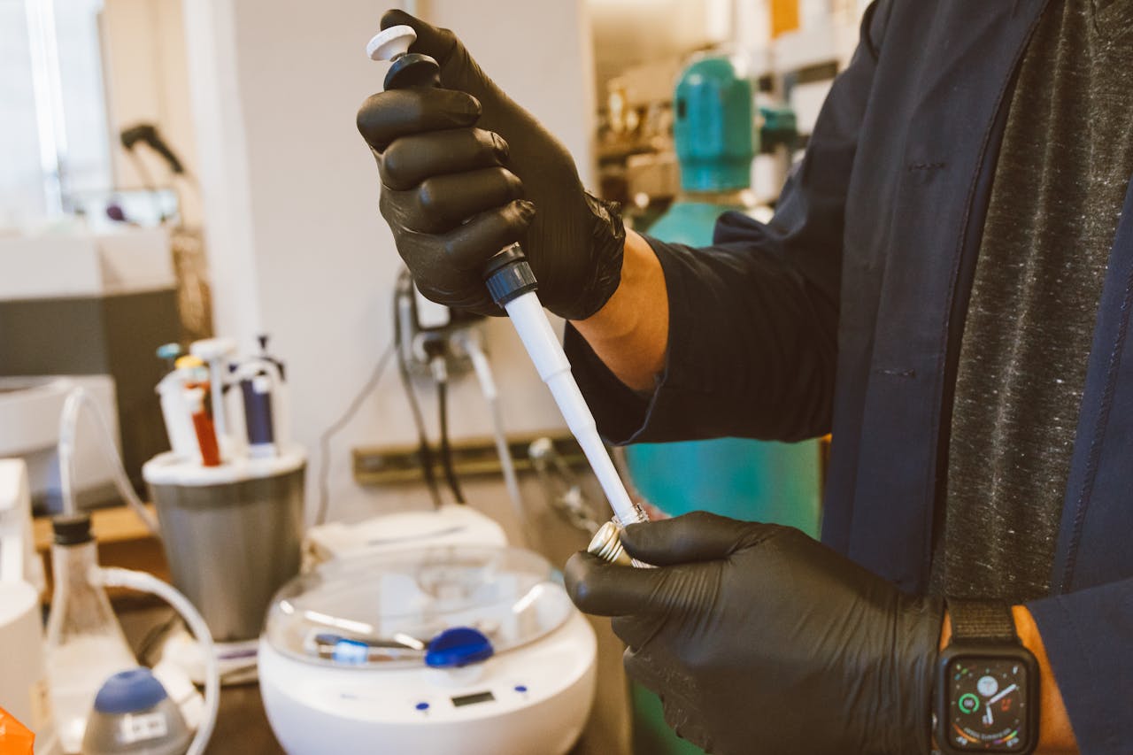 A lab technician performing an experiment with a pipette in a modern laboratory setting.